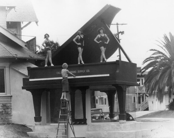 A giant grand piano marks the entrance of the California Piano Supply Co., which was renamed the Big Red Piano in the 1960s. (circa 1920s - '30s) (Photograph via Los Angeles Public Library Collection)