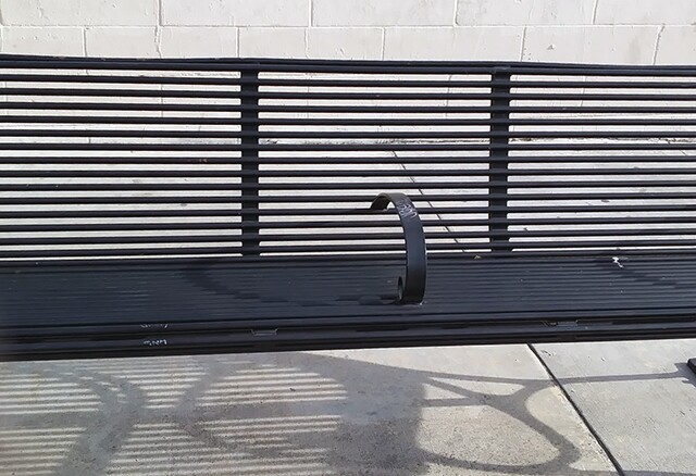 A close up of the green bench showing the bar.