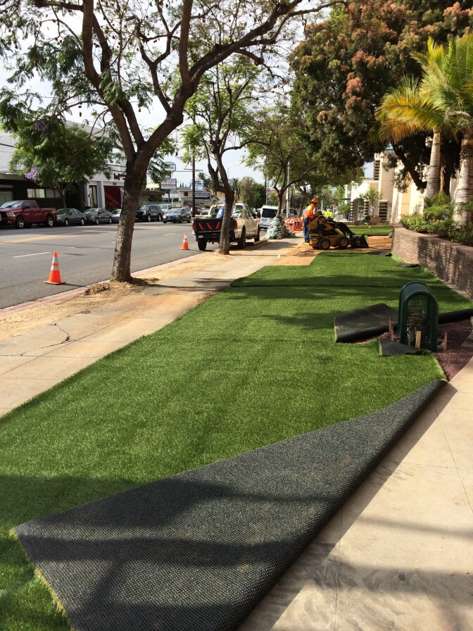 Workers install fake grass as part of a drought-tolerant lawn at the Los Angeles Department of Water and Power building in Los Feliz.  