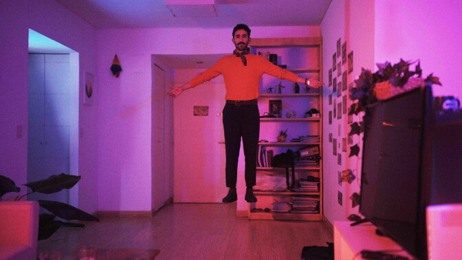 A man bathed in pink light floats above the floor in the short Trips, Friends, Night & Destiny (Los viajes, los amigos, la noche y el destino),