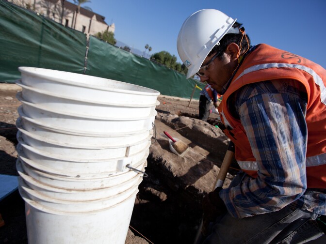 An archaeologist digs his way through dirt near the San Gabriel Mission.
