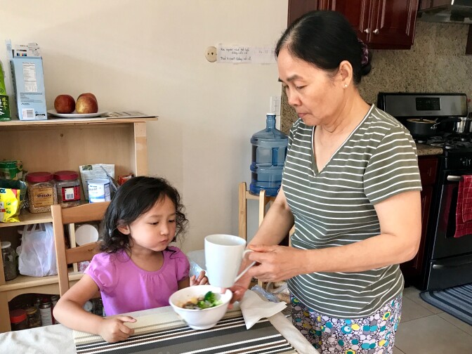 Manh Vo feeds her granddaughter Madison, 4, an after-school snack. Vo, who speaks Vietnamese, said communication with her granddaughter has improved since Madison began the Vietnamese dual language immersion program at Murdy Elementary School, Sept. 19, 2017. 
