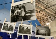 Dozens of photos are strung on clotheslines and attached by clothespins. 