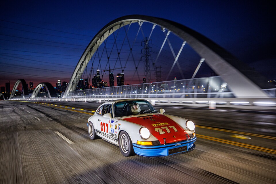 A red, white and blue Porsche drives over the 6th street bridge.