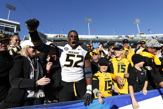 Michael Sam #52 of the Missouri Tigers celebrates with fans after the game against the Kentucky Wildcats at Commonwealth Stadium on November 9, 2013 in Lexington, Kentucky. Missouri won 48-17.  