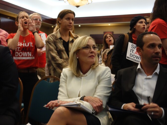                                Los Angeles County Supervisor Kathryn Barger and City Councilman Mitchell Englander remain seated while at a public meeting around them, opponents shout support for the permanent shutdown of Southern California Gas Company's Aliso Canyon natural gas storage field near Porter Ranch.