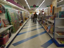 The aisle of a store covered in many kinds of visual art.