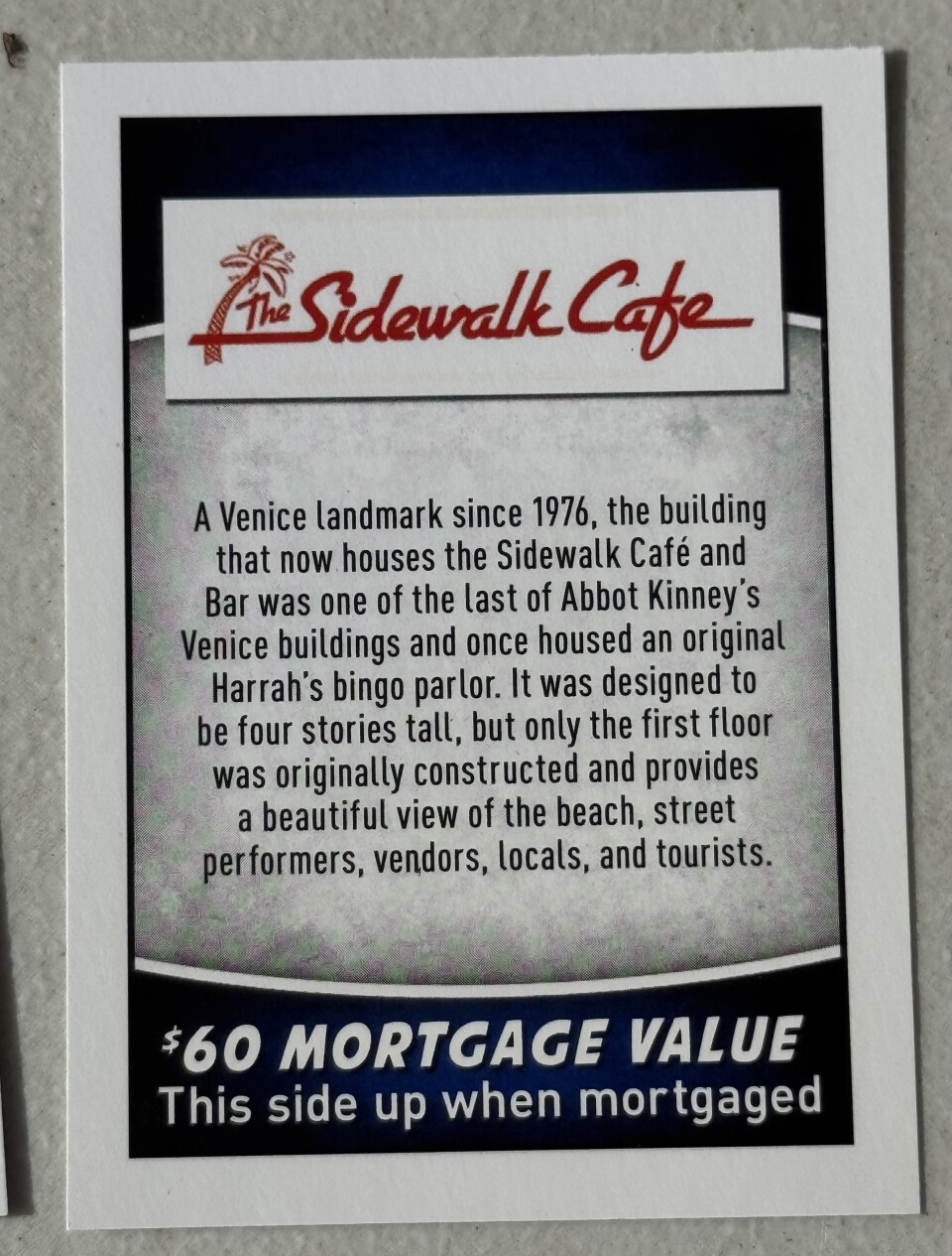 A card from a board game with a short history of a business named Sidewalk Cafe.