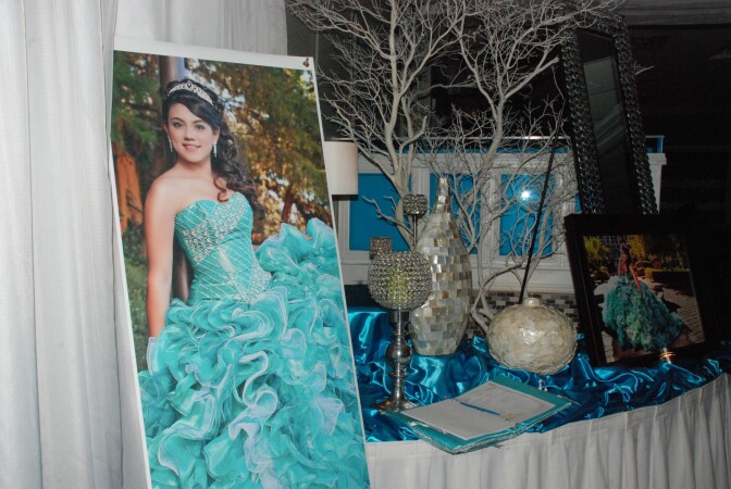 Professional photographs of Julissa Canal greet guests as they enter the hall for her quinceañera.
