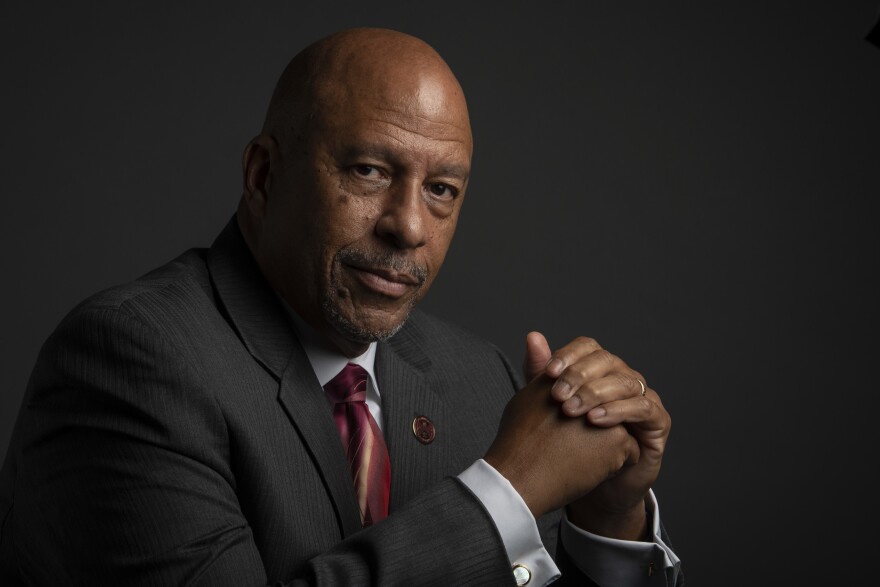 A dark-skinned man in a suit and tie.