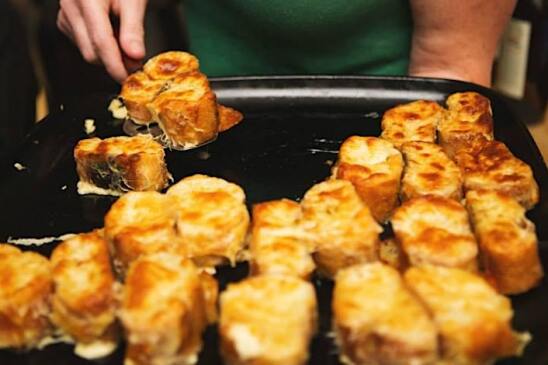 Several slices of bread with bubbly, toasted cheese on top.