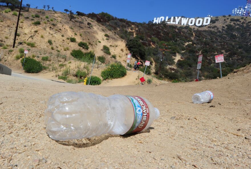 Plastic bottles lie in the foreground with the Hollywood sign behind.