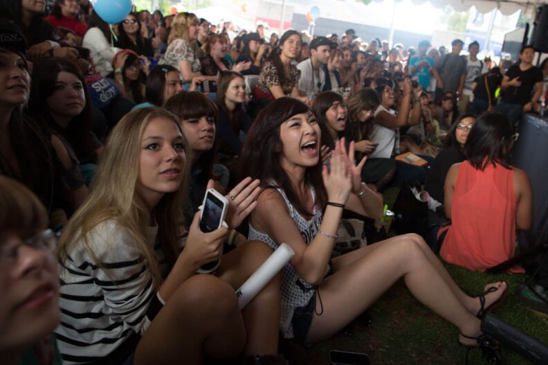 Knanh Hang cheers the arrival of stars from the K-Pop world in a convention tent. Hang traveled from Northern Virginia to attend the convention,