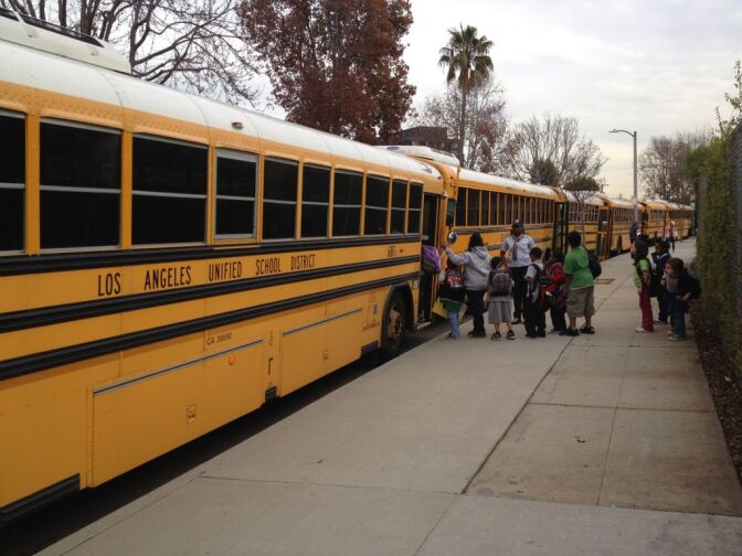 Students leaving Loyola Village Elementary School by bus.