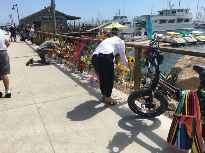 Dockside memorial, man lighting candles.