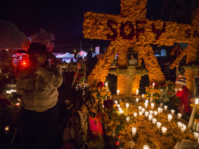 People attend to the graves of loved ones on the eve of the Day of the Dead at the cemetery of Tzintzuntzan in Patzcuaro, Michoacan, Mexico on November 1, 2016.