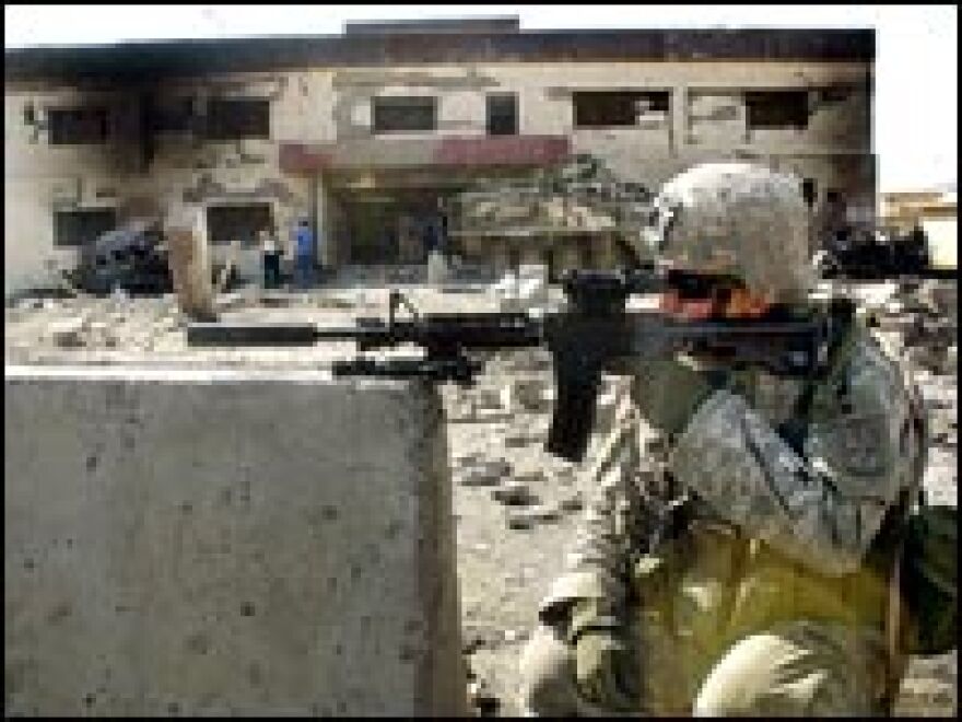 A U.S. soldier secures the area where a suicide car bomb exploded near a police station in Mosul, July 5, 2006.