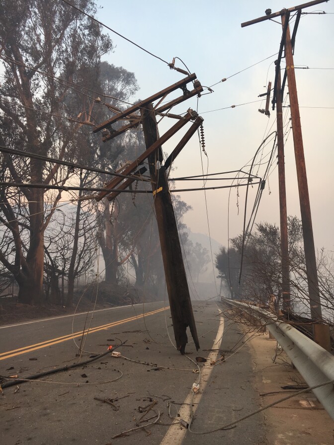 A burned-through utility pole hangs precariously over Highway 150 about a quarter mile from the origin of the Thomas Fire, near Thomas Aquinas College on Dec. 6, 2017.