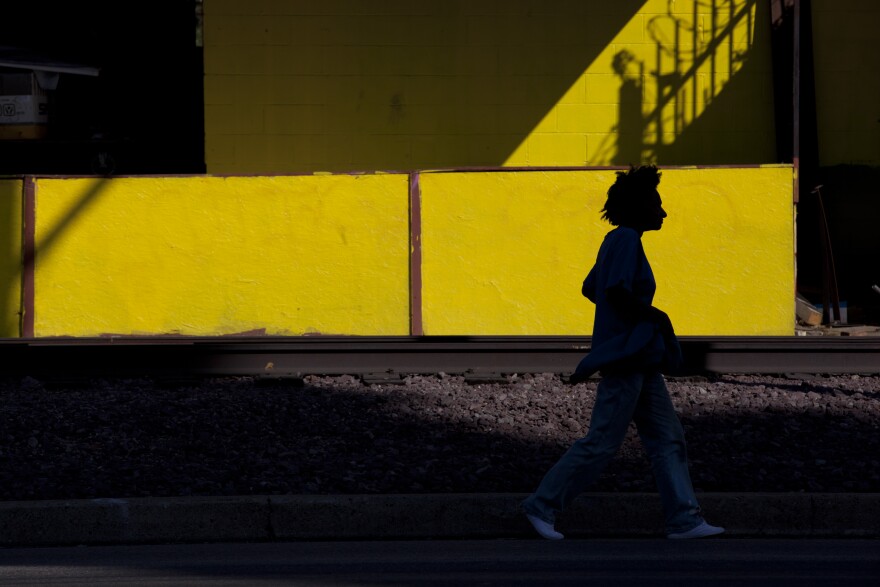 A woman walks along the train tracks on Slauson Avenue. The Metropolitan Transportation Authority is considering turning the eight miles of defunct tracks in a green space for pedestrians and bikers.