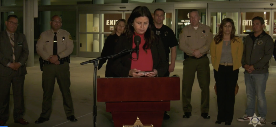 El Monte Mayor Jessica Ancona wears a red shirt and black coat as she speaks in front of LAC + USC medical center Tuesday night. Two El Monte officers were killed in what was described as a 'shootout'