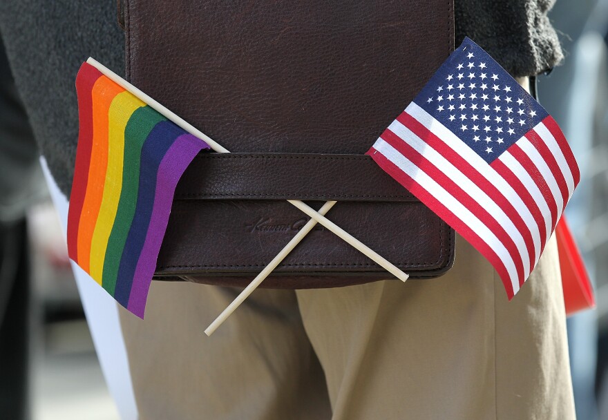 A gay pride and an American flag hang from a shoulder bag during a demonstration outside of the Phillip Burton Federal Building on June 13, 2011 in San Francisco.