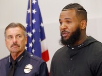 Los Angeles Police Chief Charlie Beck, left, listens as rapper The Game speaks at a news conference following a meeting he and fellow rapper Snoop Dogg had with Beck and Mayor Eric Garcetti at police headquarters in Los Angeles Friday, July 8, 2016. The rappers led a peaceful march where they urged improved relations between police and minority communities in the wake of shootings in Dallas that left five police officers dead.