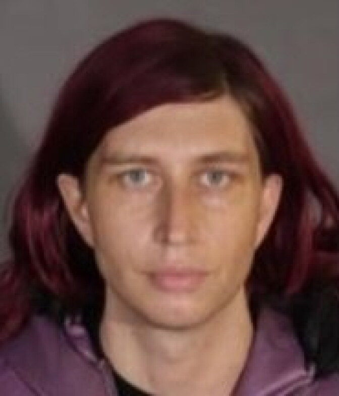 Nina Cohen, with shoulder-length brown hair, looks into the camera.