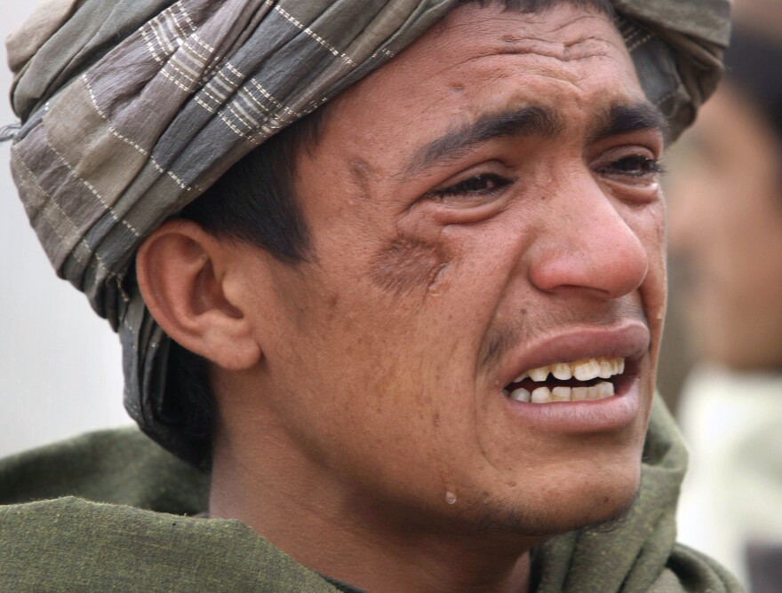 An Afghan youth mourns for relatives, who were allegedly killed by a U.S. service member in Panjwai, Kandahar province south of Kabul, Afghanistan, Sunday, March. 11, 2012. A U.S. service member walked out of a base in southern Afghanistan before dawn Sunday and started shooting Afghan civilians, according to villagers and Afghan and NATO officials.