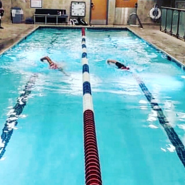 Erika Lilley and JD Rios swimming in an indoor lap pool