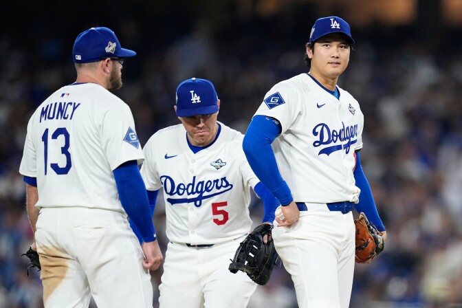 Shohei Ohtani leaves the mound as teammates gather near him.