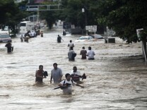 Residents attempt to flee from the flooded area in Acapulco, Guerrero state, Mexico, after heavy rains hit the area on Sept. 16, 2013.