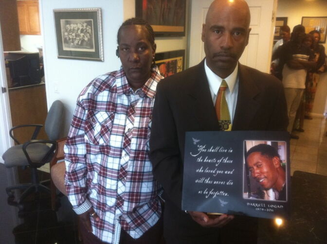 Arzenia Ratlyff and Darrell Logan hold a photo of their son Darrell Logan, Jr.