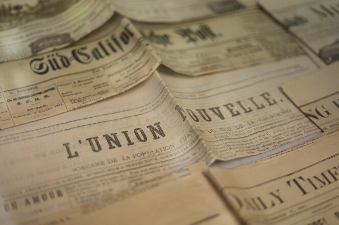 A series of yellowing newspapers with different headlines. The one in the middle says L'union nouvelle