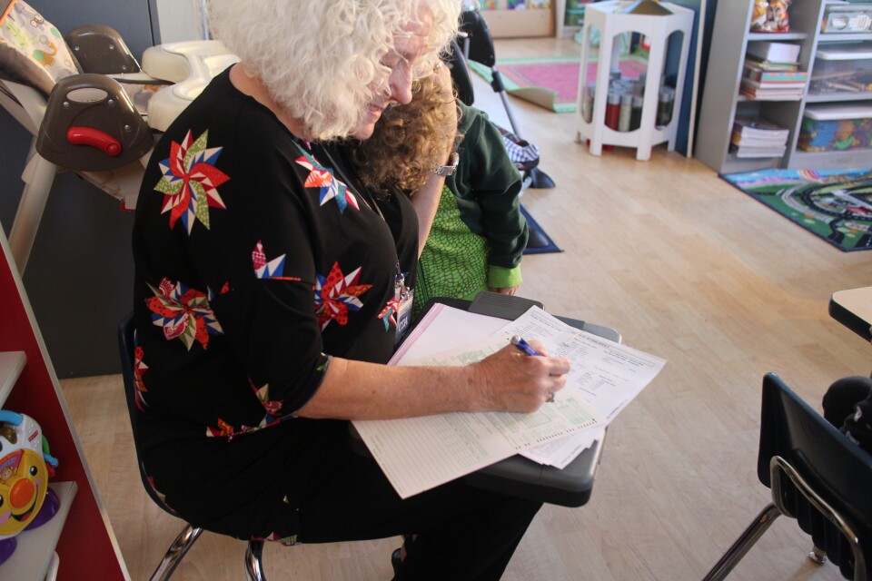 Karen Kiernan hugs a child while observing a meal at Jessica Horn's home day care in Riverside, Calif.