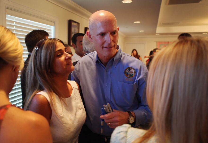 Florida Governor Rick Scott greets people during a bill signing ceremony for House Bill 99, the Florida Safe Harbor Act and House Bill 7049, Human Trafficking, at the Kristi House in Miami. on June 12, 2012 in Miami, Florida.  The Governor is in a legal battle with the U.S. Justice Department over the state's effort to remove non-U.S. citizens from lists of registered voters ahead of this year's presidential election.