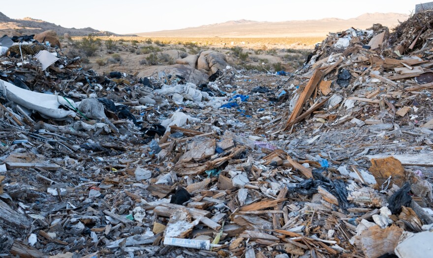 Large piles of trash in the desert.