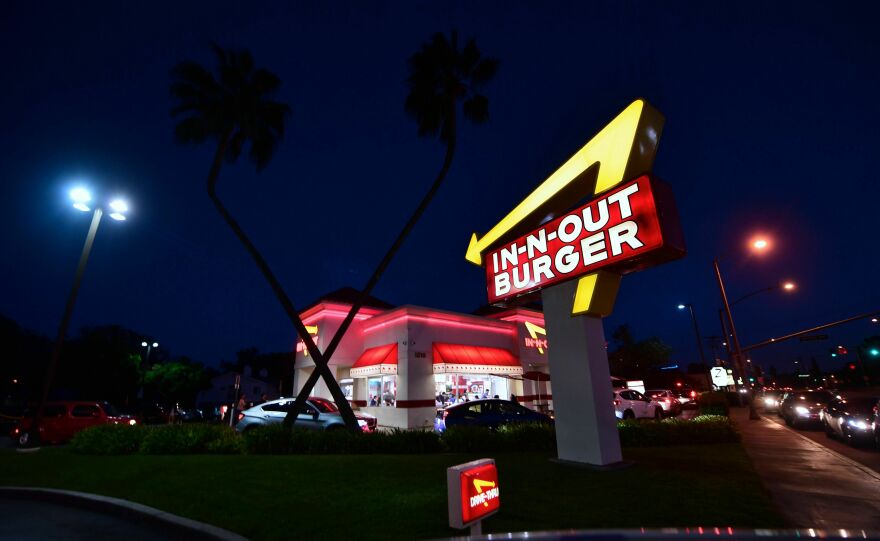 A lighted arrow yellow arrow points at a drive thru. It reads: In-N-OUT BURGER