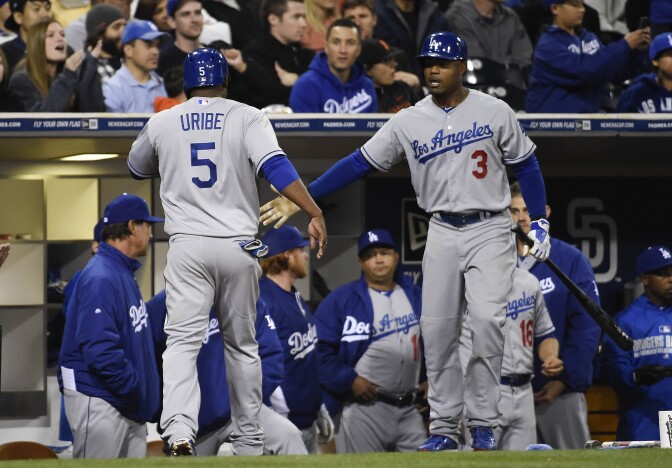 SAN DIEGO, CA - APRIL 2:  Juan Uribe #5 of the Los Angeles Dodgers is congratulated by Carl Crawford #3 after scoring during the eighth inning of a baseball game against the San Diego Padres at Petco Park April 2, 2014 in San Diego, California.  (Photo by Denis Poroy/Getty Images)