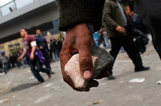 Anti-government protesters carry rocks to throw at pro-government supporters near a highway overpass on the edge of Tahrir Square the afternoon of February 3, 2011 in Cairo, Egypt.