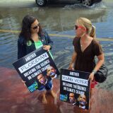 Jacquie Ayala (L) and Amanda Lawrence stand in a flooded street as they and others call on the presidential candidates to talk about their plans to fight climate change on October 18, 2012 in Miami Beach, Florida.  Some of the streets on Miami Beach are flooded due to unusually high tides that the protesters felt are due to rising seas, which are connected to global warming and climate change. Published reports indicate that Florida ranks as the most vulnerable state to sea-level rise, with some 2.4 million people, 1.3 million homes and 107 cities at risk from a four-foot rise in sea levels. 