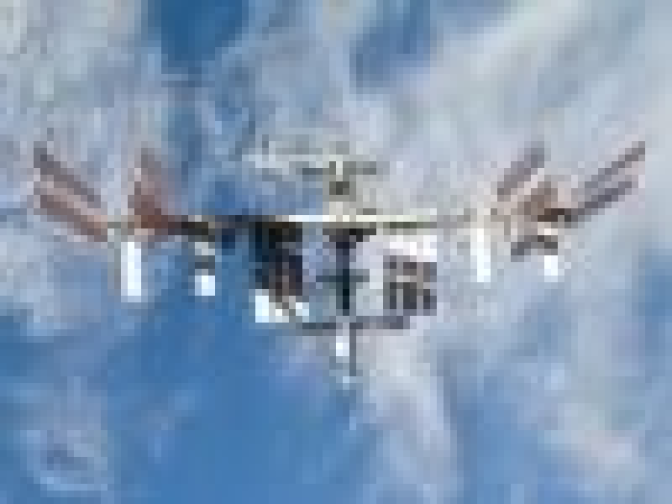 Backdropped by a blue and white part of Earth, the International Space Station is seen from space shuttle Discovery as the two spacecraft begin their relative separation. Undocking occurred at 2:26 p.m. CDT. 