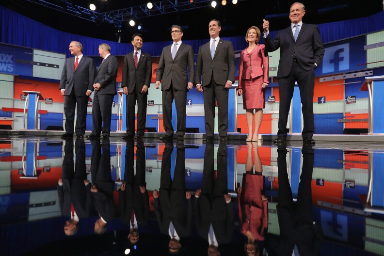 Republican presidential candidates (L-R) Jim Gilmore, Sen. Lindsey Graham (R-SC), Louisiana Gov. Bobby Jindal, Rick Perry, Rick Santorum, Carly Fiorina and George Pataki pose for a photograph at the beginning of a presidential forum hosted by FOX News and Facebook at the Quicken Loans Arena August 6, 2015 in Cleveland, Ohio.
