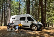 Patrick and Arthur at a campsite with their van and two dogs.