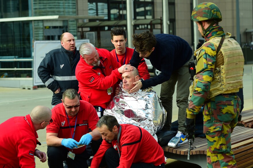 A victim receives first aid by rescuers, on March 22, 2016 near Maalbeek metro station in Brussels, after a blast at this station near the EU institutions caused deaths and injuries.