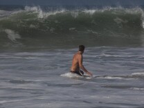 Steve West, 42, wades into the ocean to body surf in Huntington Beach as Hurricane Marie brings a big swell to the California coast.