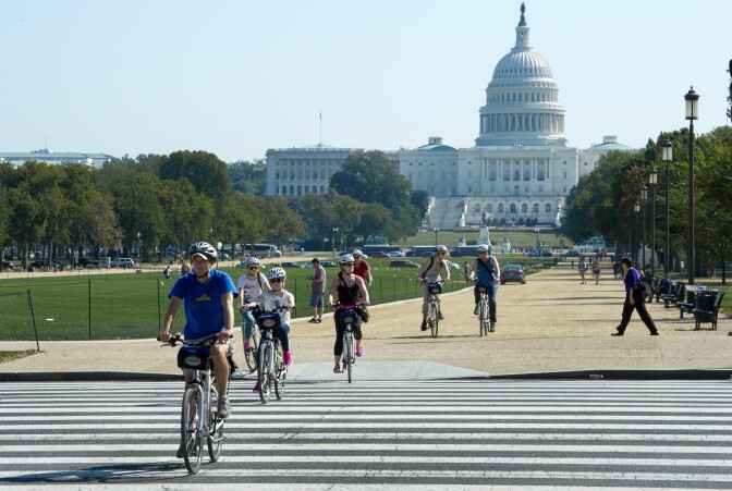 Tourists ride bicycles down the National Mall in Washington, DC, October 1, 2013, as the first US Federal government shutdown since 1995 begins. The US Park Police have closed off the mall to vehicle and pedestrian traffic due to the US Government partial shutdown. A spokesperson for the US National Park Service said it is technically illegal to use the mall. 