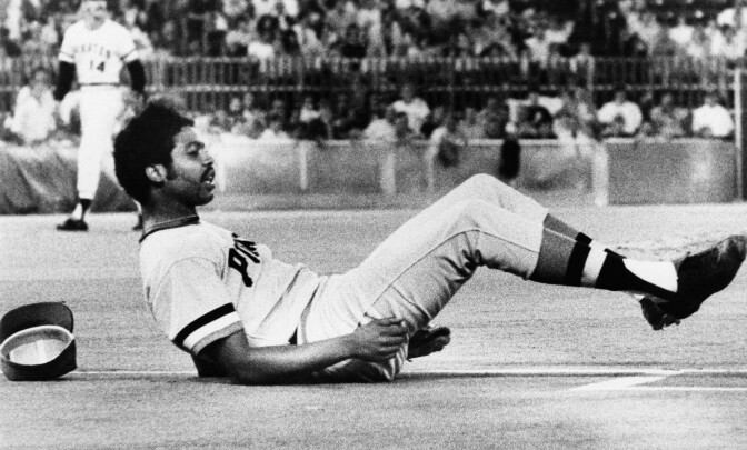 Pittsburgh Pirates Pitcher Dock Ellis is on the ground as he watches his throw go wild to Bob Robertson at first in 6th inning of Pirates vs. Philadelphia Phillies game Wednesday, Sept. 11, 1974 in Philadelphia, Pa.