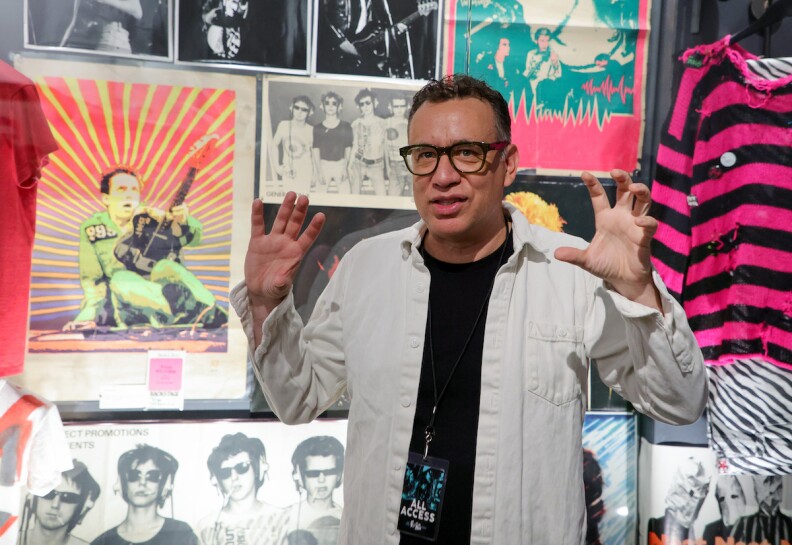 ellie goulding tour 2023 Fred Armisen in a white jacket and black t-shirt speak with his arms outstretched in front of a display case at The Punk Rock Museum in Las Vegas.