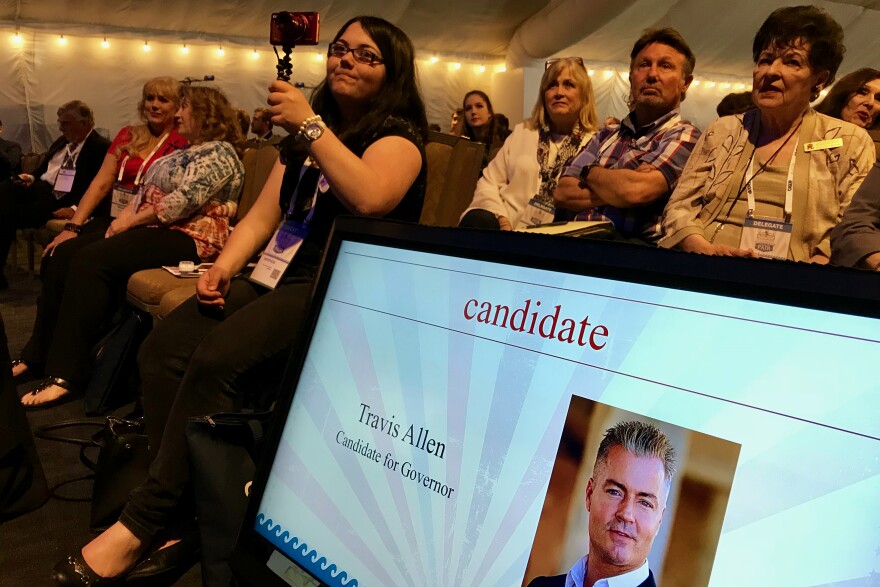 Attendees of the California Republican Party convention watch gubernatorial candidate Travis Allen on stage in San Diego.