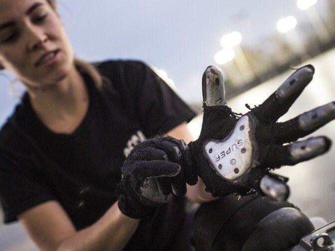 Team Member Ruth Duckworth puts on sliding gloves before a practice for Decayed Brigade at Chapman Sports Park in Garden Grove on Monday evening, Oct. 24, 2016. Much of the group's equipment is DIY – many team members adhere heel taps to gloves for sliding.